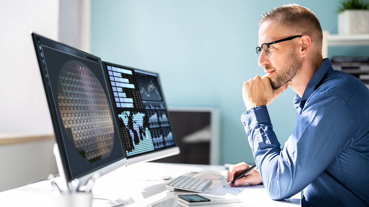 man looking at computer displays