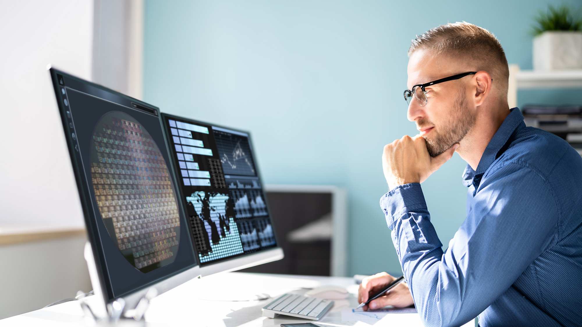 man looking at computer displays