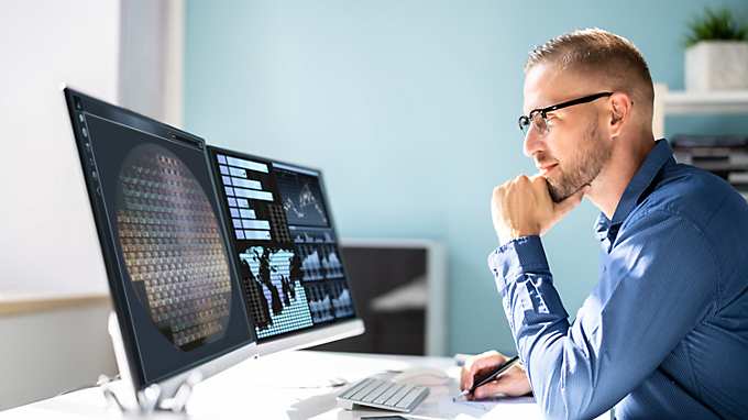 man looking at computer displays