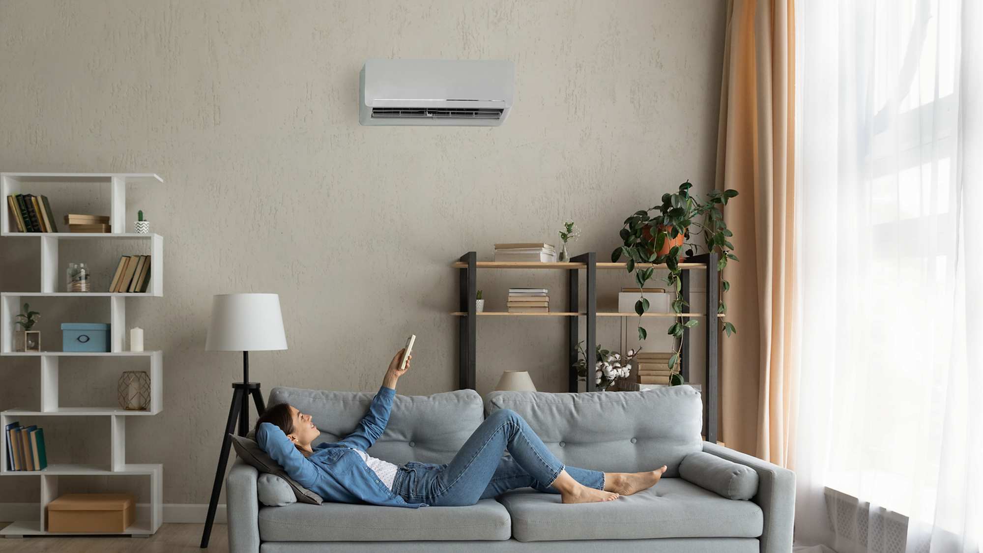 Woman lying on couch with Air Condition in living room