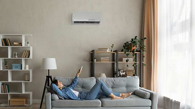 Woman lying on couch with Air Condition in living room