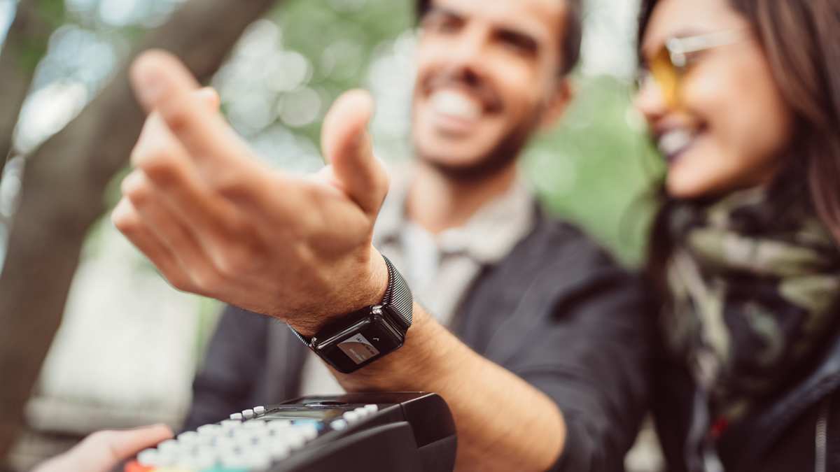 man paying contactless with smartwatch