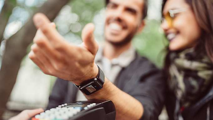man paying contactless with smartwatch